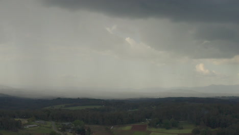 cámara haciendo zoom, revelando un paisaje natural bajo una densa extensión de nubes