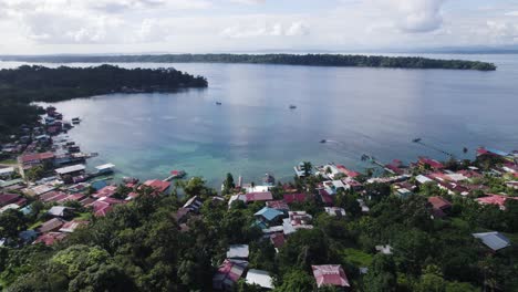 Vista-Aérea-De-La-Pintoresca-Costa-De-Las-Islas-Bastimentos-En-Panamá,-Con-Casas-Coloridas-Y-Exuberante-Vegetación-Junto-Al-Agua.