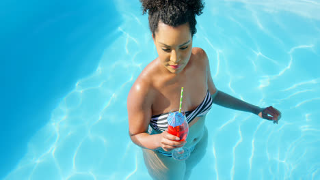 high angle view of young mixed-race woman drinking cocktail in swimming pool 4k