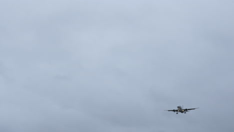 jumbo jet plane coming into land in gray-stormy weather shot in 4k high resolution