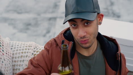 Cámara-Lenta,-Atractivo-Joven-Bebiendo-Alcohol-Haciendo-Tostadas-Disfrutando-De-Una-Fiesta-En-La-Azotea-Sentado-En-El-Sofá-Con-Una-Refrescante-Cerveza-Celebrando-El-Fin-De-Semana