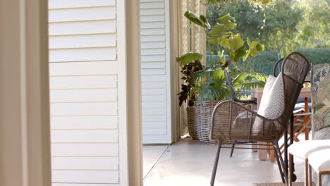 two wicker chairs with cushions resting on sunny porch