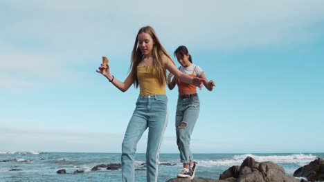 front view of a caucasian and a mixed race girl eating ice cream seaside