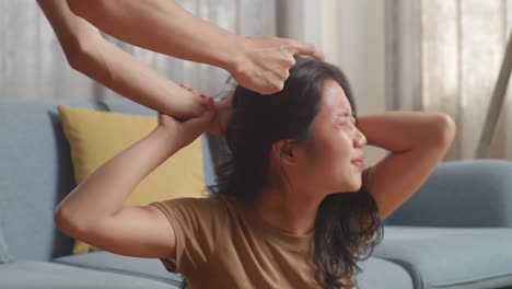 close up of young asian woman victim of violence with bruise on body abused by man's hands pulling her hair while being shouted at home