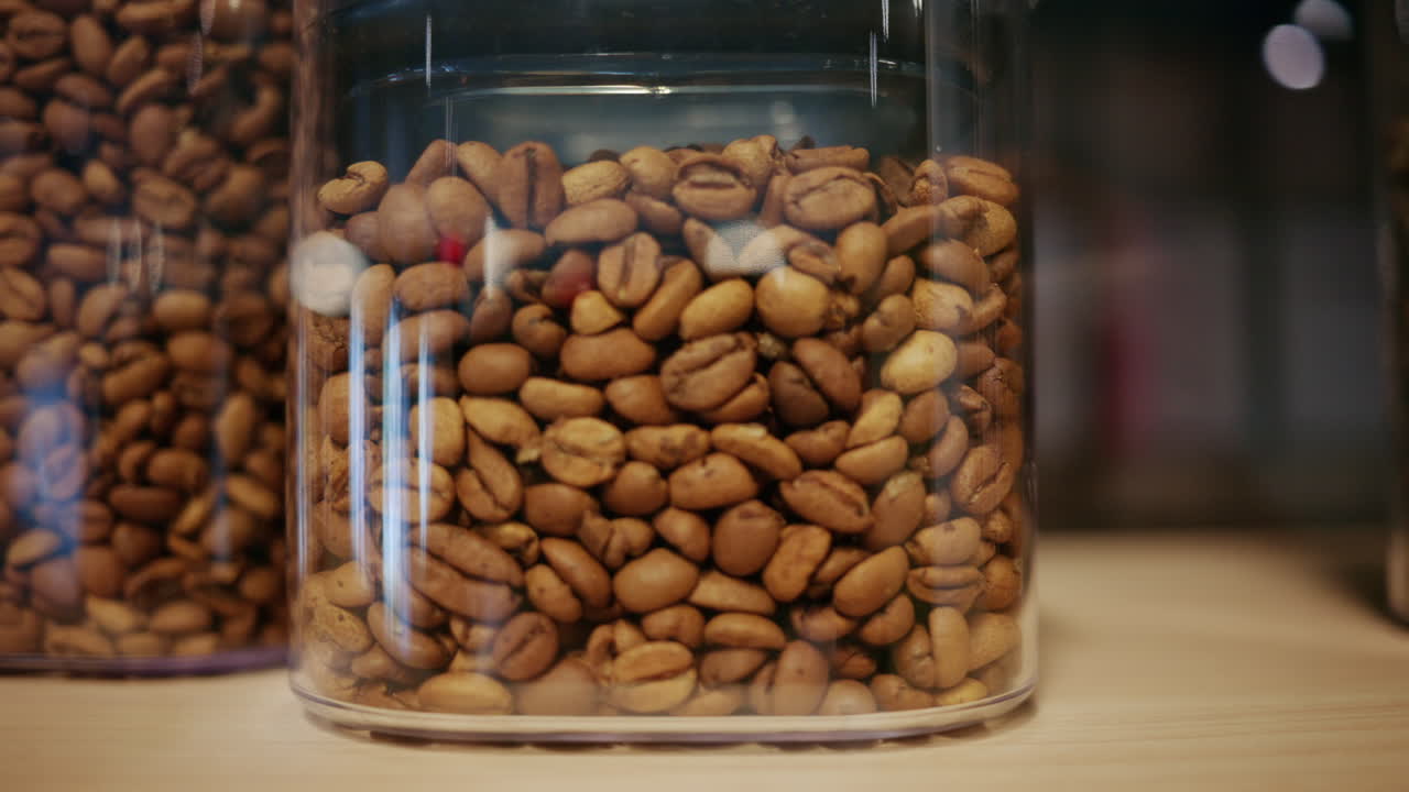 Detalhe de grãos de café torrados armazenados em um recipiente transparente