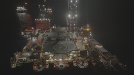 Imágenes-De-Drones-De-Un-Barco-De-Servicio-Trabajando-En-Una-Plataforma-Petrolera-Por-La-Noche