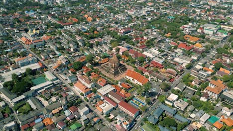 4k cinematic urban drone footage of a panoramic aerial view of the temple of wat chedi luang in the center of the city of chiang mai, thailand on a sunny day