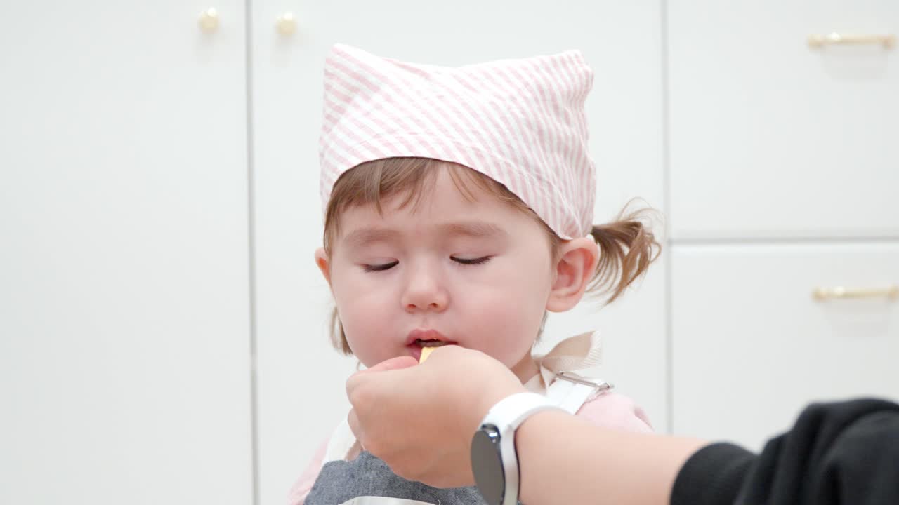 엄마가 먹인 키즈 카페에서 셰프 의상을 입은 배고픈 아이