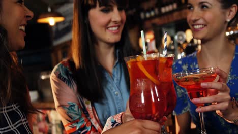 friends toasting drinks together in bar