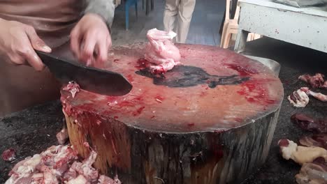 a man selling chicken pieces in the market