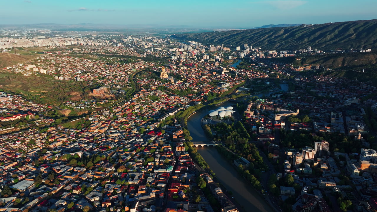 Drone view above downtown Tbilisi, showcasing the vibrant capital of Georgia with striking buildings, busy streets, and a dynamic urban landscape from above.