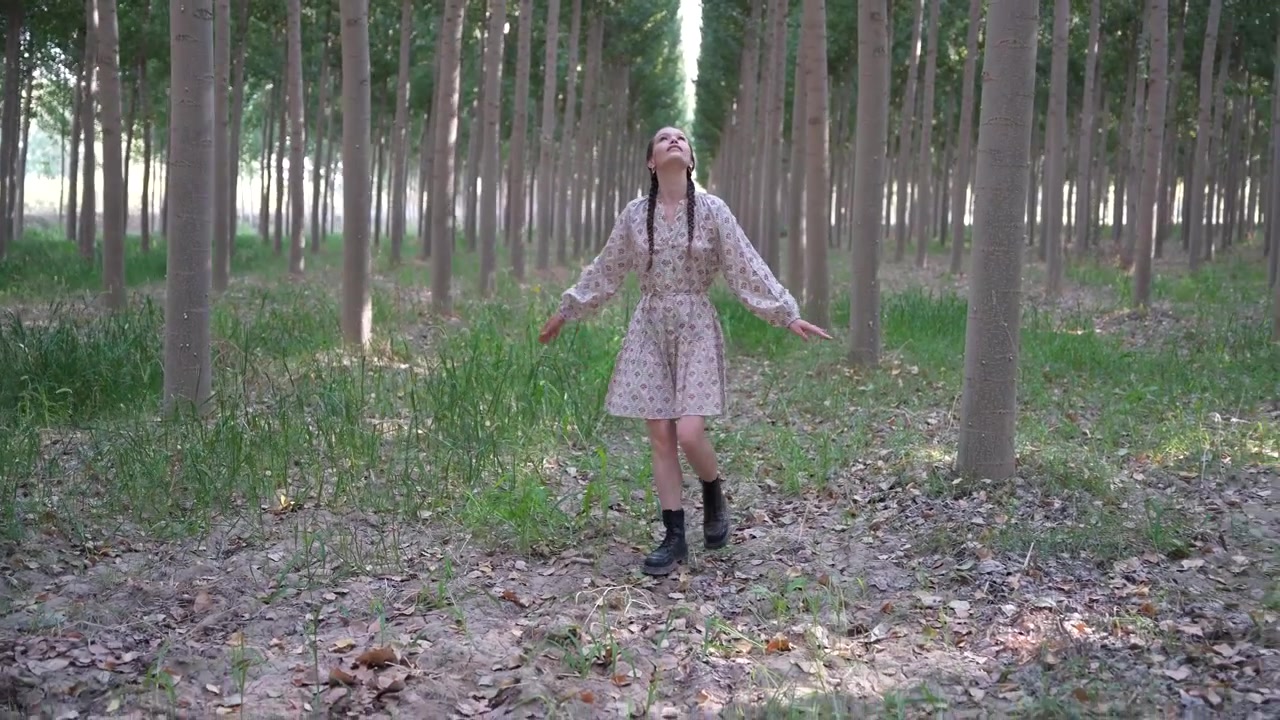 Una donna vestita con un bellissimo abito floreale cammina attraverso una serena foresta lussureggiante.