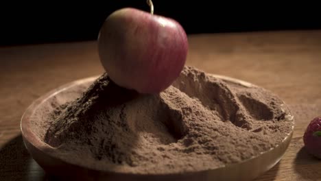 movimiento lento de manzana fresca cayendo en chocolatey cacao en polvo,1000 fps