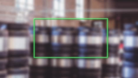 animating green rectangle over blurred industrial barrels in warehouse