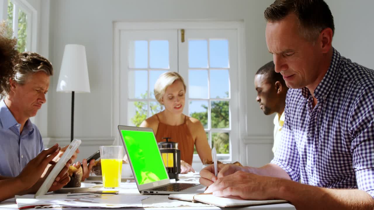 Group of executive interacting while having breakfast