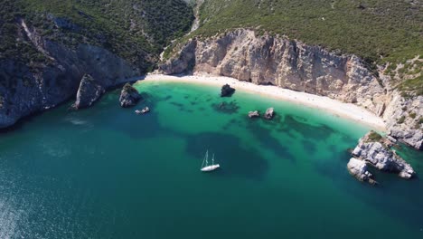 Toma-Aérea-Ascendente-De-Un-Yate-Amarrado-En-Una-Playa-De-Aspecto-Tropical-En-Portugal