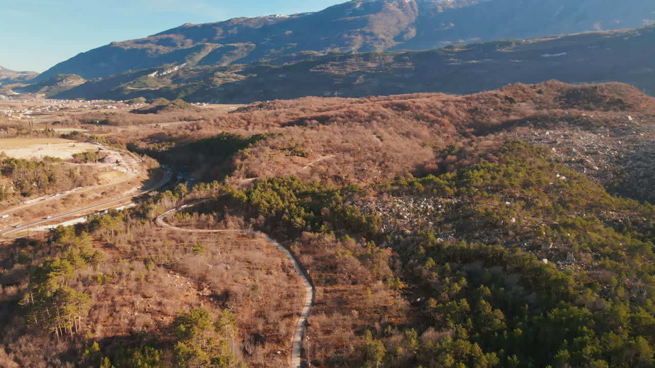 Carretera rural con bosques y valles cerca del paisaje montañoso de Trentino en Italia.