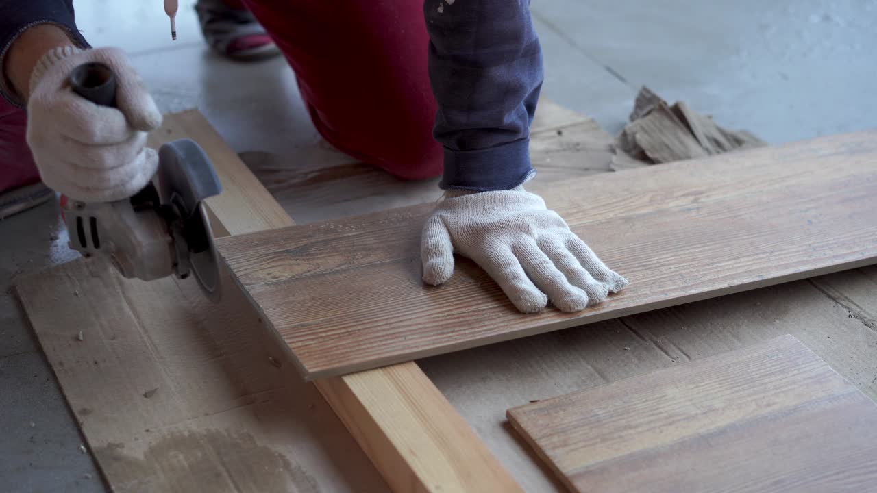 repair and decoration. a man cuts ceramic tiles with a grinder.
