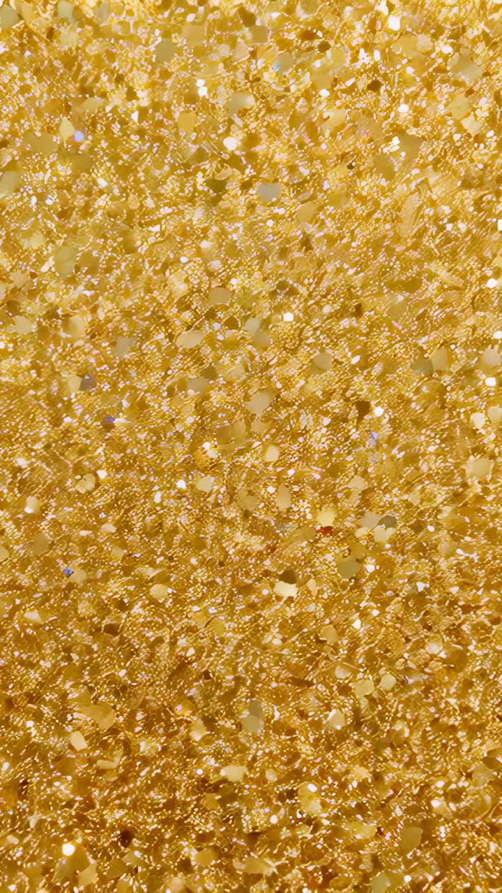 Vertical video: Moving camera capturing closeup gold sequins, highlights drifting to reveal shimmer