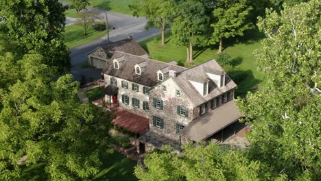 aerial reveals sprawling stone mansion set among green trees in united states