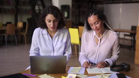 Retrato-De-Estudiantes-Alegres-Que-Estudian-En-La-Biblioteca-Con-Una-Laptop