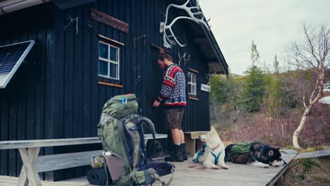 a hiker, with his two dogs, opens a cabin near reinsjøen in åfjord, trøndelag, norway - static shot