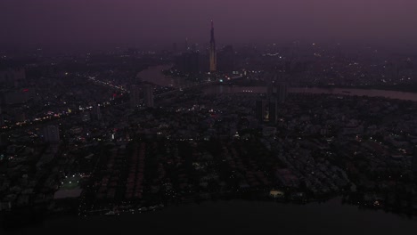 Vista-Aérea-De-La-Ciudad-De-Ho-Chi-Minh-Y-El-Río-Saigón-En-El-Crepúsculo-Con-Luz-Ambiental-Y-Artificial