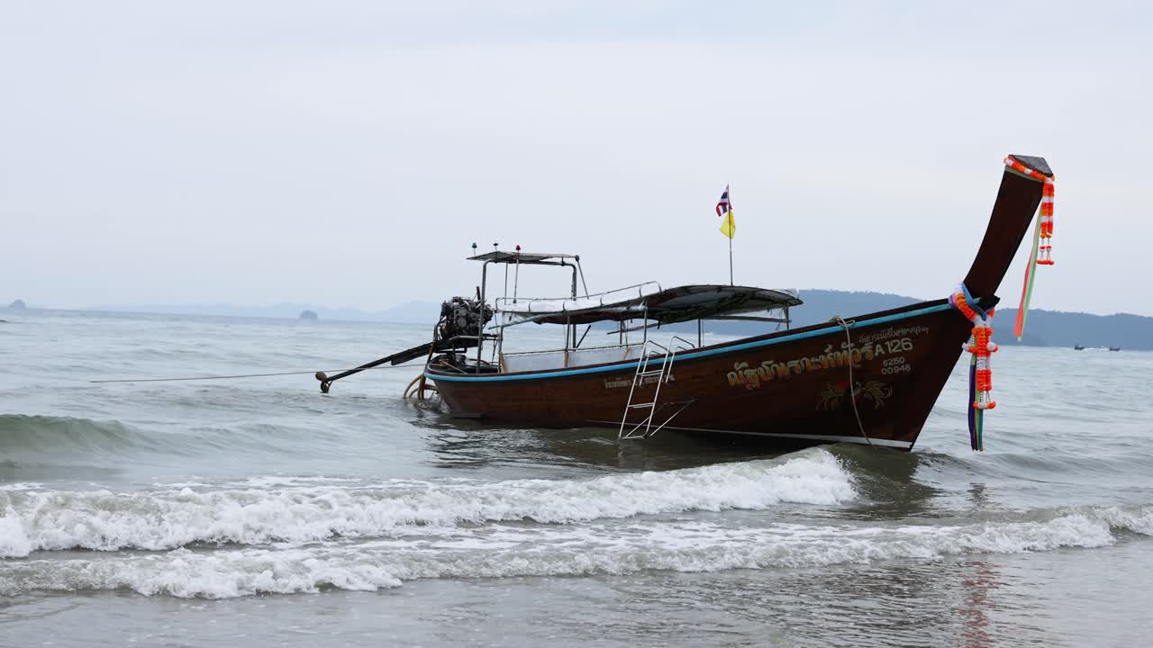 el barco se balancea suavemente en la costa de krabi.