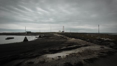 Strandfußweg-Aus-Der-Luft,-Der-Zum-Leuchtturm-Auf-Der-Insel-Grotta,-Reykjavik,-Island,-Dunkle,-Wolkige,-Stimmungsvolle-Landschaft-Führt