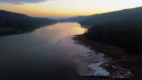 Dämmerungsreflexionen-An-Einem-Ruhigen-Fluss-Inmitten-Bewaldeter-Hügel