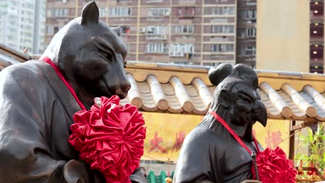 animal statues adorned with red flowers in hong kong