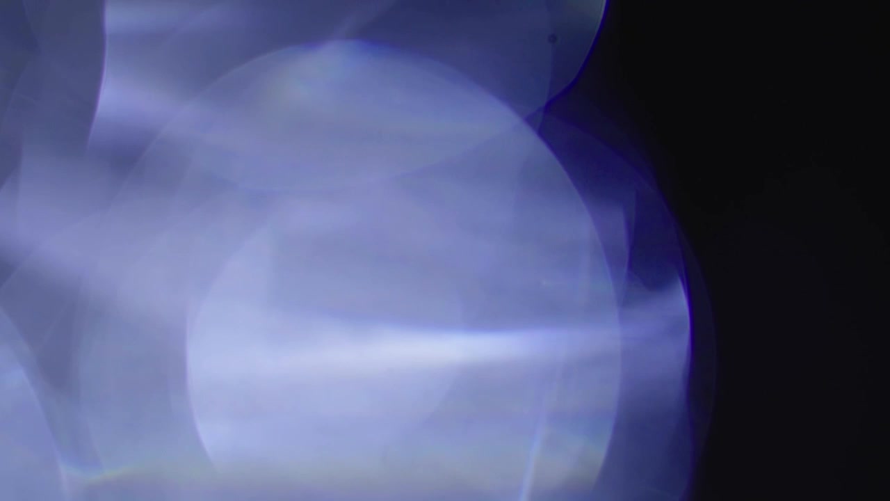 Ethereal Blue and Purple Light Leaks Moving Across Dark Screen