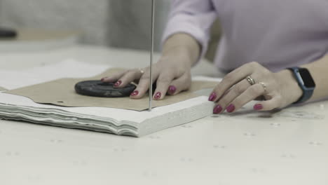 mujer usando una máquina para cortar patrones de tela