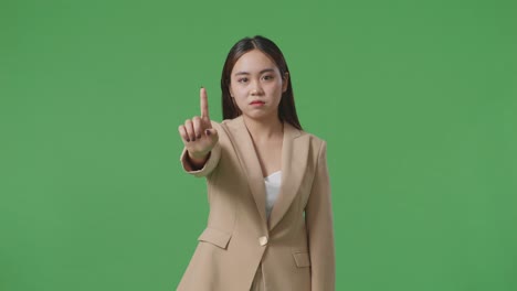 woman in beige suit pointing finger