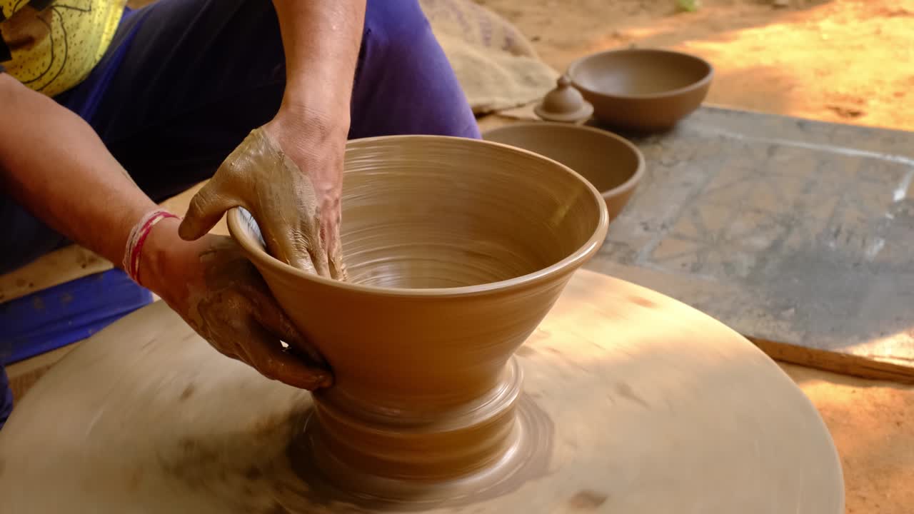 las manos hábiles del alfarero moldeando el barro en la rueda del alfarer y esculpindo jarras de barro. shilpagram, udaipur, rajasthan, india