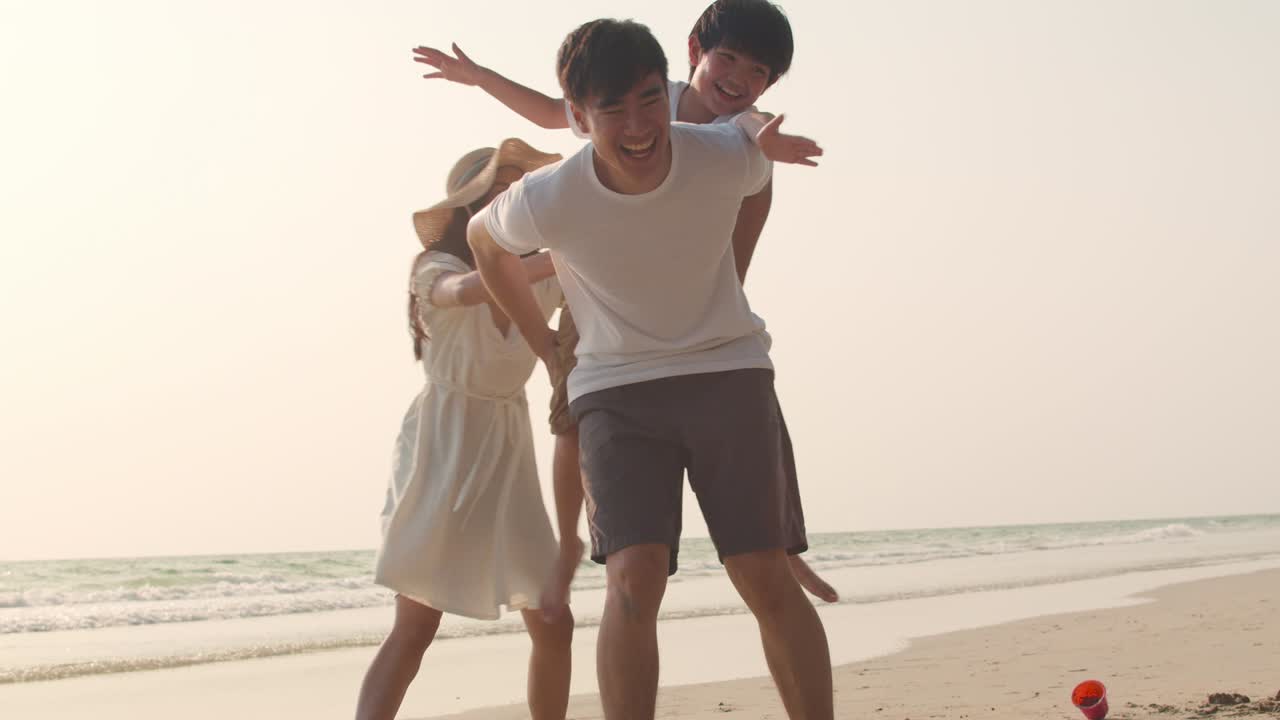 젊은 아시아 행복한 가족은 저녁에 해변에서 휴가를 즐기고 있습니다.