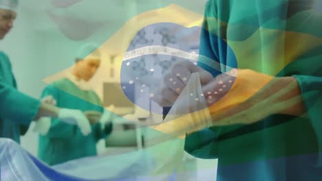 Animation-of-flag-of-brasil-waving-over-surgeons-in-operating-theatre