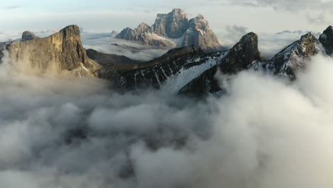 vista aérea inclinada sobre la niebla, hacia picos rocosos de piedra caliza, amanecer en el tirol, italia