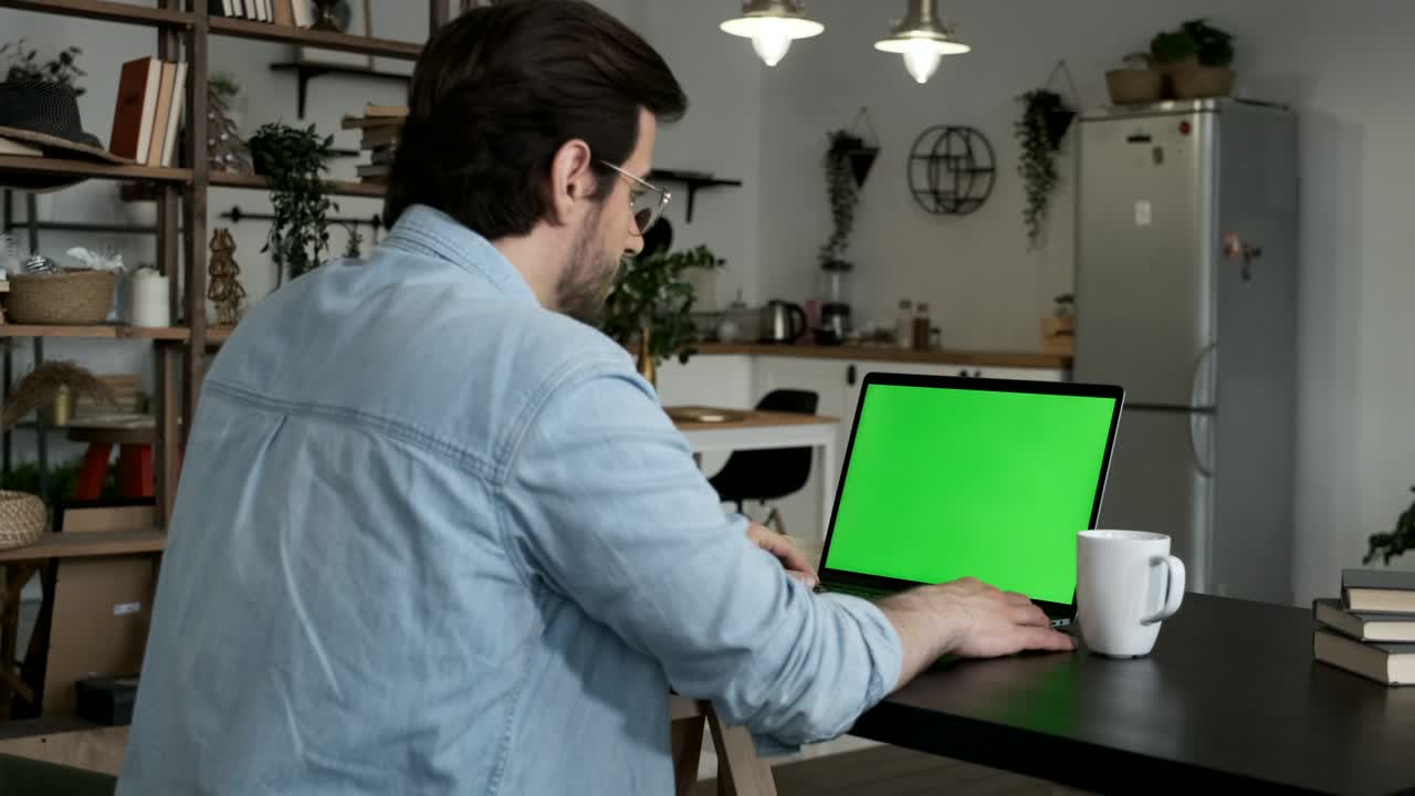 joven usando pantalla verde tecla de croma computadora portátil mecanografía trabajando en oficina ligera con computadora moderna. tecnología, copyspace y concepto de trabajo.