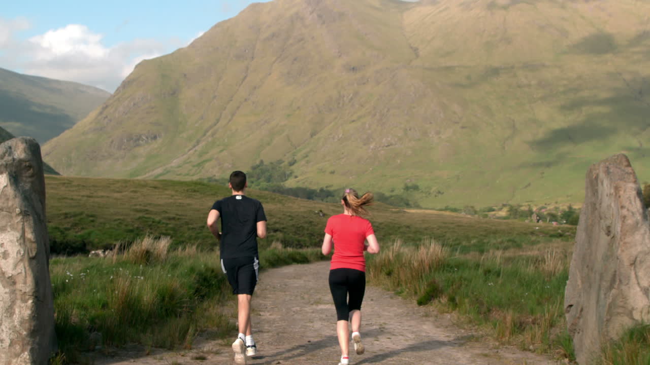 Man jogging and is met by his jogging girlfriend in the countryside