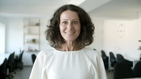 cheerful middle aged caucasian woman looking at camera.