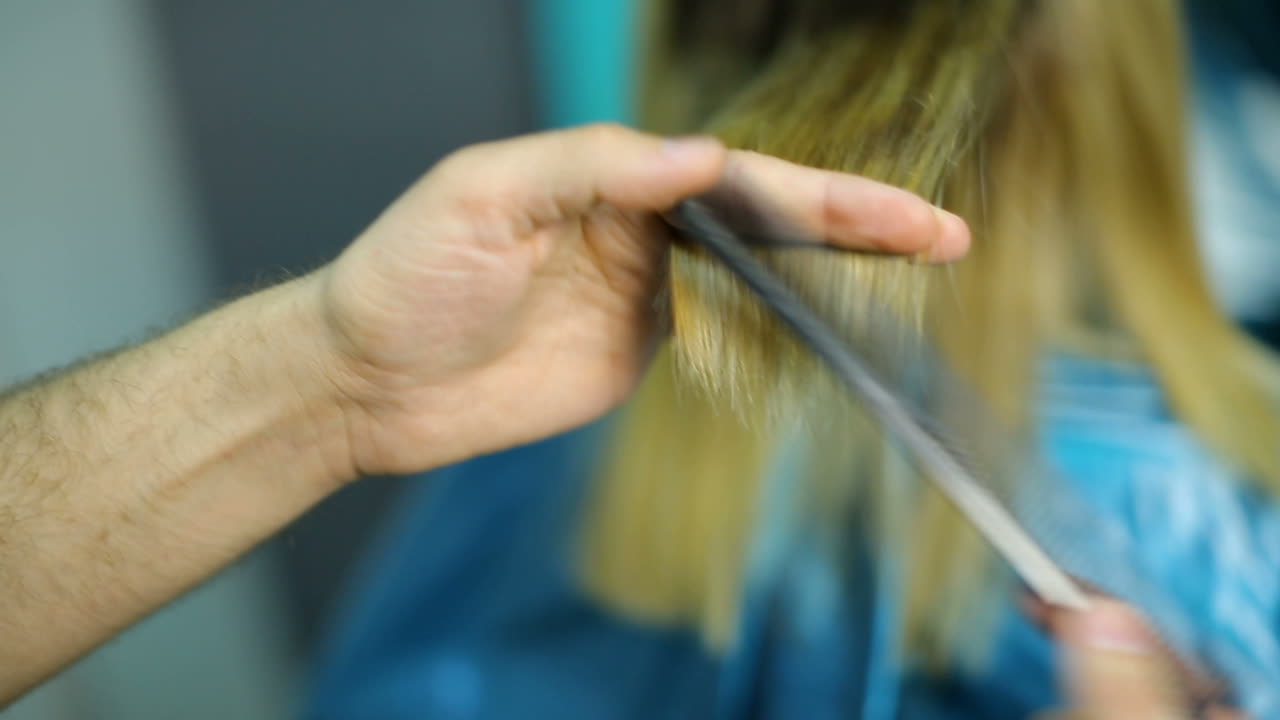 Hairdresser cutting hair of her customer at the hairdressing salon