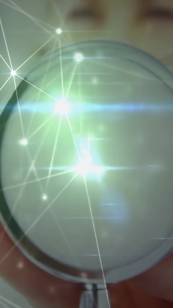 Vertical video: Woman holding mirror, tilting to check face, causing beauty overlay and flare