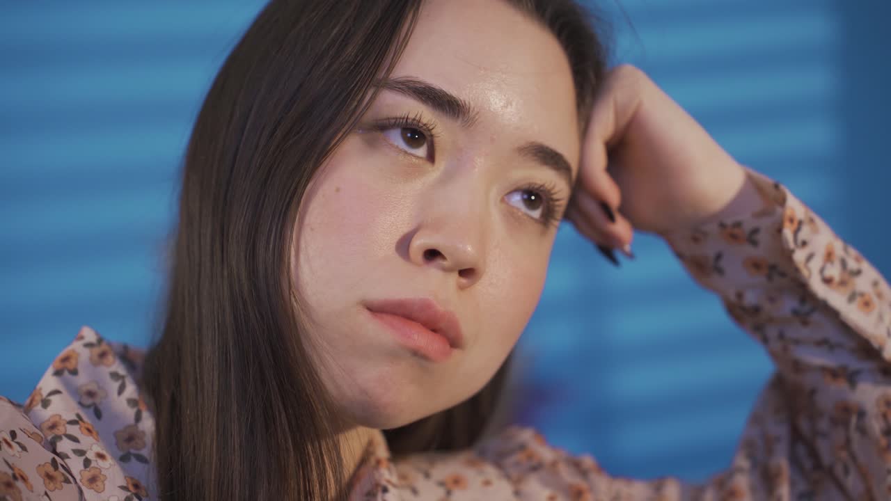 불행하고 우울한 아시아 젊은 여성은 압도당하고 생각하고 있습니다.