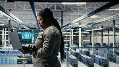 it expert monitors server farm activity using laptop while walking in facility