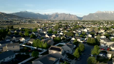 viviendas unifamiliares en un típico barrio suburbano en un valle debajo de las montañas rocosas - vista aérea panorámica de paralaje