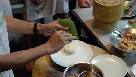 hands of chef folding banana leaf for thai dish - slow motion