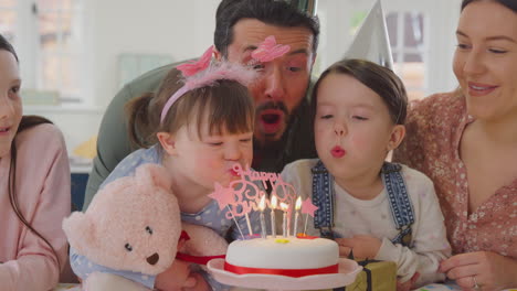 family with down syndrome daughter celebrating birthday with party at home together