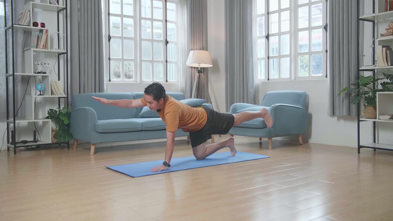 家でヨガのポーズをしている男性