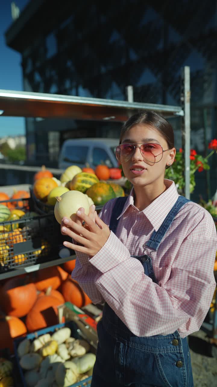 mujer examinando calabazas en un mercado de agricultores